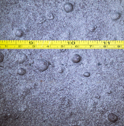 Image of pipeline showing corrosion with a tape measure for sizing.