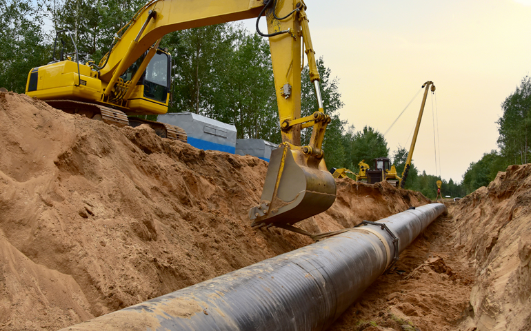 Excavator digs over a pipeline, a major cause of mechanical damage.